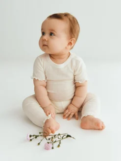 Kortærmet body med hulmønster i merinould/silke til baby