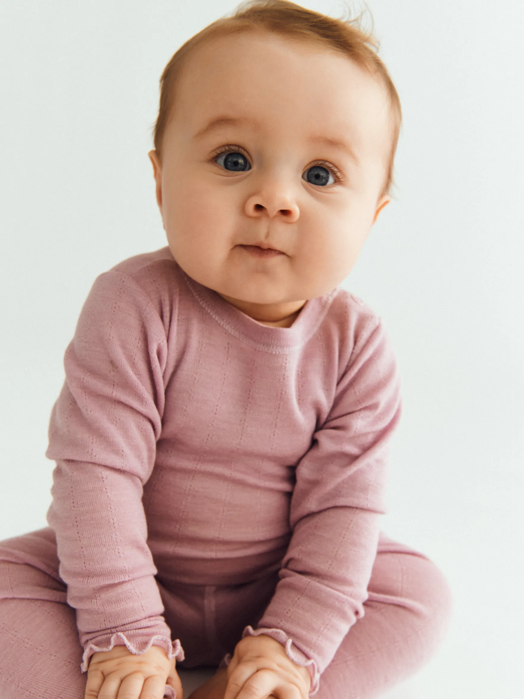 Langærmet body med hulmønster i merinould/silke til baby